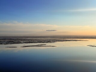 Fototapeta premium quiet yellow sunset sky reflection on the water surface, sea horizon, beautiful and peaceful