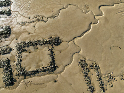 Aerial view of oyster beds mosaic the expansive mudflats, a textured tapestry of nature's artistry, Bourcefranc-le-Chapus, Bourcefranc-le-Chapus, France.