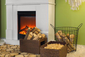 Obraz premium Wooden box and basket with firewood near fireplace in living room