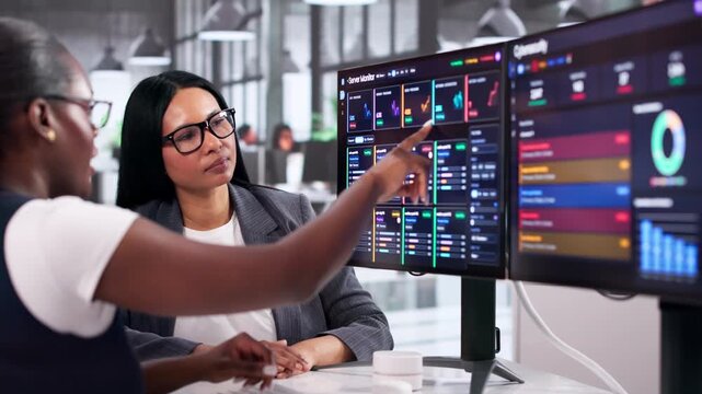 Two Women Work Together Using Cybersecurity Software