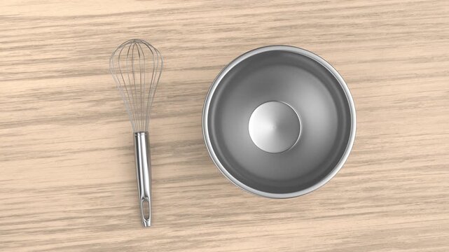 Balloon whisk and empty metal bowl on a wooden table