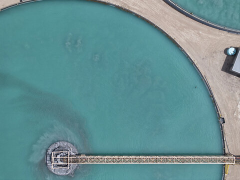 Aerial view of striking turquoise industrial basins contrasting sharply with the parched, light-toned earth, Tucson, Arizona, United States.