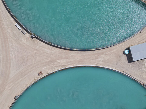 Aerial view of vibrant turquoise pools of water cutting through the dry, earthy terrain, creating a stark geometric contrast, Tucson, Arizona, United States.