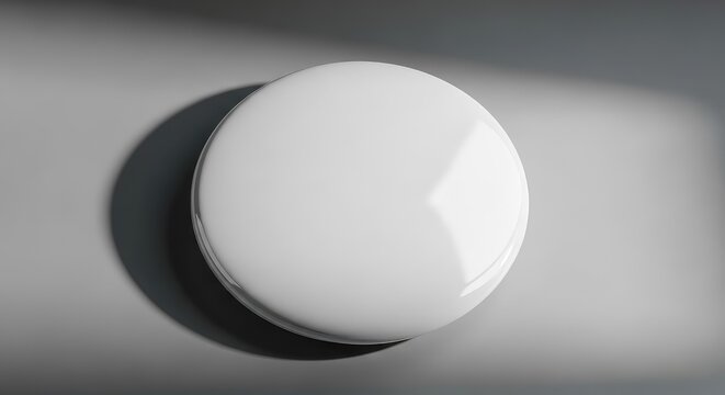 A blank white metal pin button sits on a neutral surface with soft shadows, highlighting a glossy finish and round shape for custom designs, realistic, merchandise, design