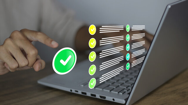 Businessman reviewing electronic files on laptop via intelligent management system to validate records and streamline final approvals, featuring green checkmark icons for quality assurance concept