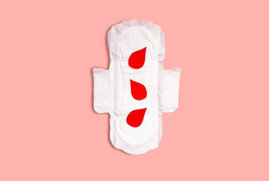 Menstrual pad with red drops on pink background. Menstruation cycle period, woman hygiene and comfort concept