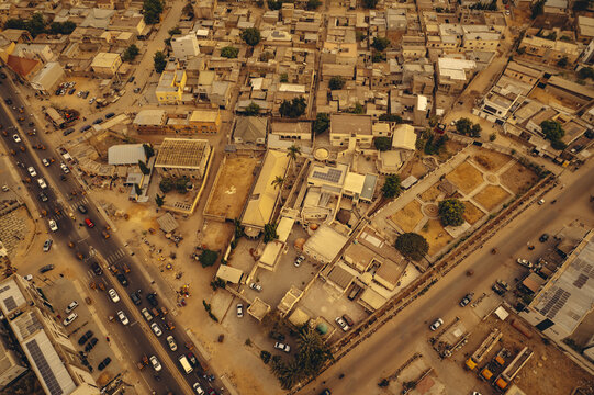 Aerial view of a sprawling urban landscape where golden-hued structures meet dark, bustling thoroughfares, revealing a vibrant tapestry of life, Tarauni, Kano, Nigeria.