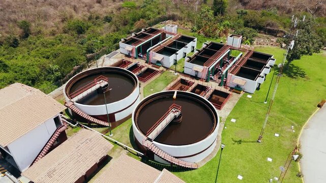 Aerial view of a water treatment plant featuring circular clarifiers and rectangular aeration tanks surrounded by green lawns in Puerto Vallarta, Jalisco, Mexico.