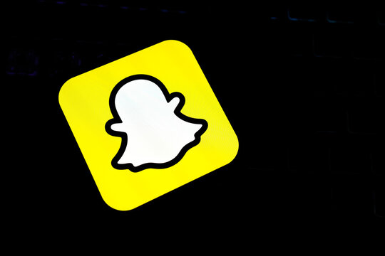 Close-Up of the Snapchat Ghost Icon on a Vibrant Yellow Square Glowing Against a Dark Background, Representing Social Media Trends, Instant Messaging, and Gen Z Digital Lifestyle Aesthetics.