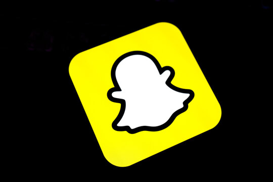 Close-Up of the Snapchat Ghost Icon on a Vibrant Yellow Square Glowing Against a Dark Background, Representing Social Media Trends, Instant Messaging, and Gen Z Digital Lifestyle Aesthetics.