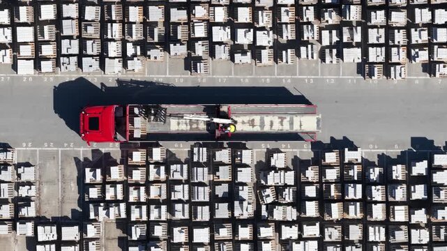 Aerial view of truck crane loading concrete slabs in industrial area