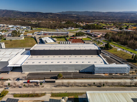 Aerial view of a large industrial complex with contrasting textures and forms against a backdrop of rolling hills, Albergaria-a-Velha, Aveiro District, Portugal.