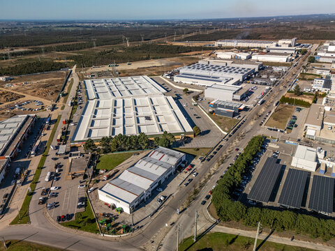 Aerial view of industrial buildings with geometric patterns of roofs, casting shadows on the ground, Albergaria-a-Velha, Aveiro District, Portugal.