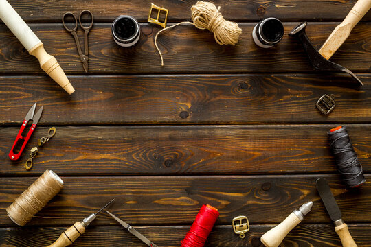 Frame flat lay of leather craftsman or shoemaker tools and equipment, top view