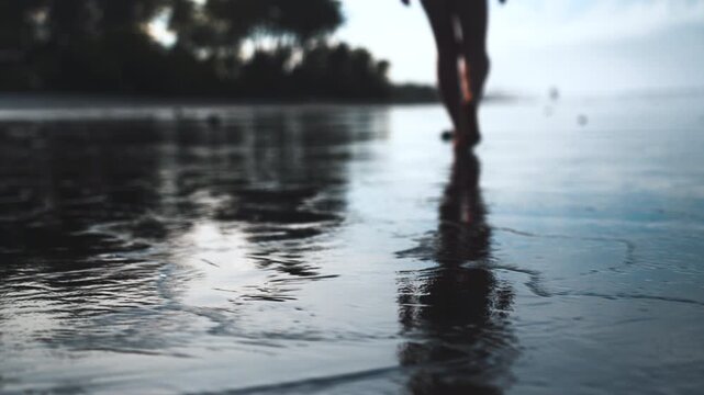 Close Up of Bare Feet Walking on Wet Beach Sand