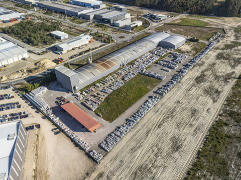 Aerial view of a grey industrial factory, concrete product storage, and raw earth, Gafanha da Encarnacao, Aveiro District, Portugal.