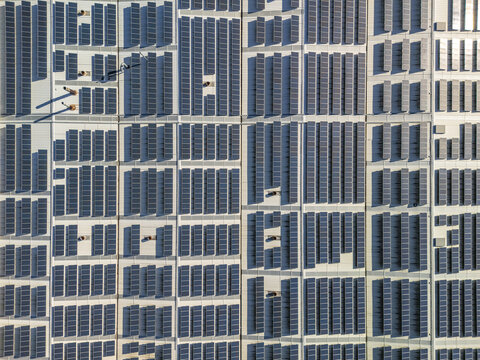 Aerial view of dark solar panels on bright rooftops, a vast geometric pattern for clean energy, Gafanha da Encarnacao, Aveiro District, Portugal.