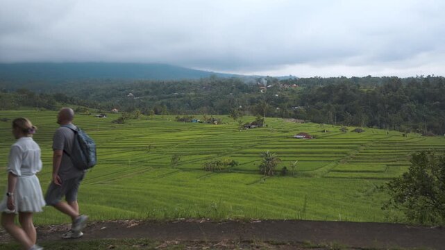 Two Tourists Walking Past Jatiluwih Rice Terraces in Bali