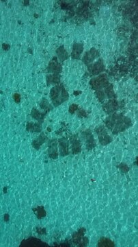 Vertical Aerial of Pristine Coral Reef and Turquoise Lagoons surrounding Tropical Island in the South Pacific