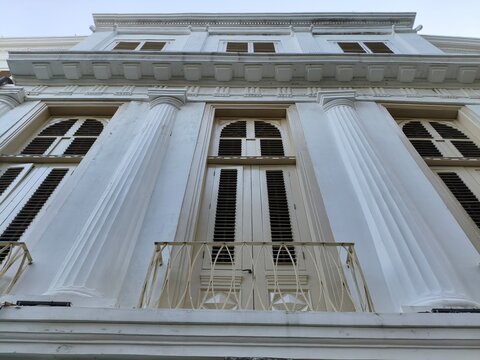 white classical builiding facede with colomns and balcony