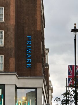 London UK 06.07.2025 Primark store sign on brick building facade with blue illuminated logo and british flag on street in central london retail district