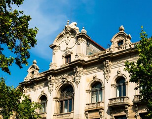 Obraz premium Ornate, cream-colored historical building with intricate stone carvings, arched windows, and a rooftop. Sunlight is evident on the facade