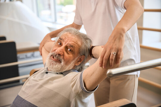 Elderly Caucasian man receiving physical therapy assistance indoors
