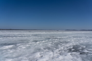Obraz premium A Vast Frozen Landscape Under Clear Skies: The Beauty of Ice and Blue in a Winter Wonderland