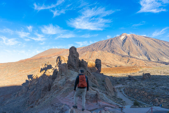 A tourist with a backpack is watching the Los Roques de Garcia cliffs in Teide National Park.