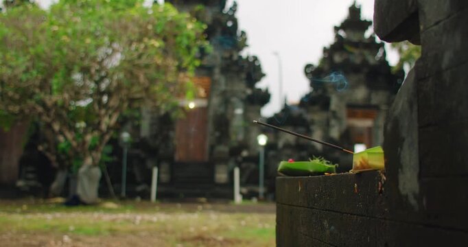 Scented incense smoke rises from offerings at ancient temple sanctuary in Bali