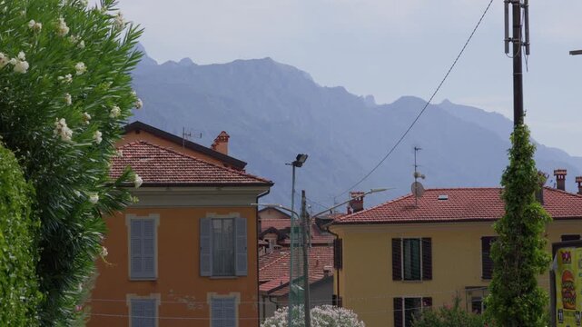 Typical Architecture And Lush Vegetation Backdropped By Grigne Mountains In Menaggio, Como, Italy. elevated shot