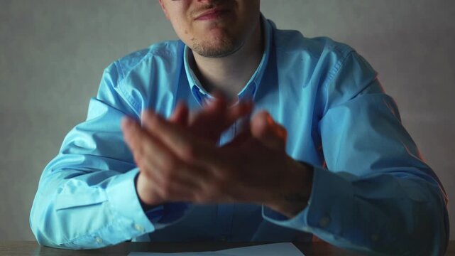 Unhappy office worker sitting at desk giving ironic applause, expressing sarcasm and disappointment with colleagues performance. Corporate conflict and negative feedback concept.