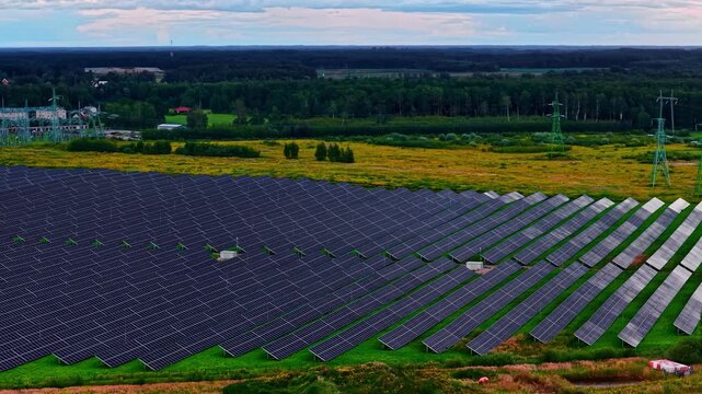 Solar panels generating clean electricity with power grid substation next to it