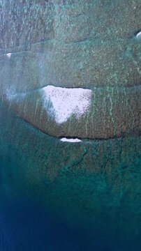 Vertical Aerial of Pristine Coral Reef and Turquoise Lagoons surrounding Tropical Island in the South Pacific