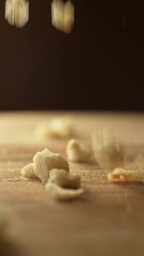 Bread crumbs falling on a wooden board
