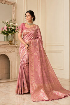Premium full-length photoshoot of an elegant Indian model wearing a luxurious dusty rose pink silk saree with rich golden zari weaving.