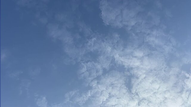 Altocumulus cloud timelapse blue sky with mackerel clouds moving fast in daylight full frame background sky_010