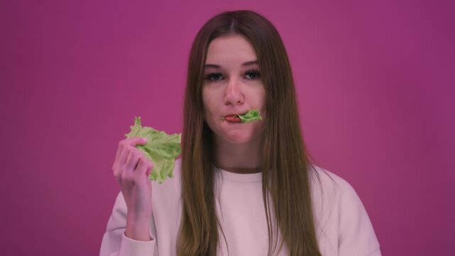Young teen girl eating lettuce leaves, fresh healthy salad. Woman enjoying healthy food and clean eating lifestyle. Female have a organic vegetables, vegetarian diet concept, wellness, nutrition,