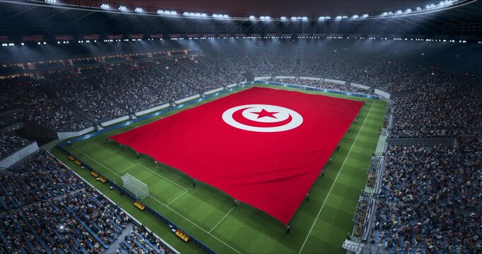 Professional Stadium With Soccer Game Championship With Flag of Tunisia Spread Across Pitch Before Football Match Start. Cheering Crowds of Fans at Arena in Looking at Ceremony. Aerial Wide Shot