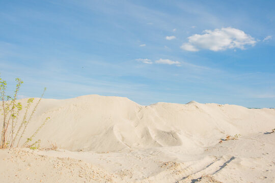 View of white sand dunes under a clear blue sky with sparse green vegetation Futog, Vojvodina, Serbia.