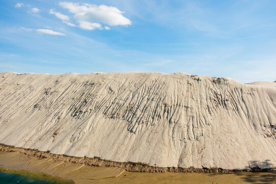 View of a massive sand pile with erosion rills under a clear blue sky at an excavation site in Futog, Vojvodina, Serbia.