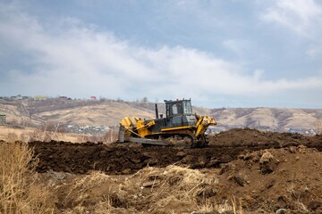 Obraz premium A bulldozer works on the construction of a new road. Construction equipment.