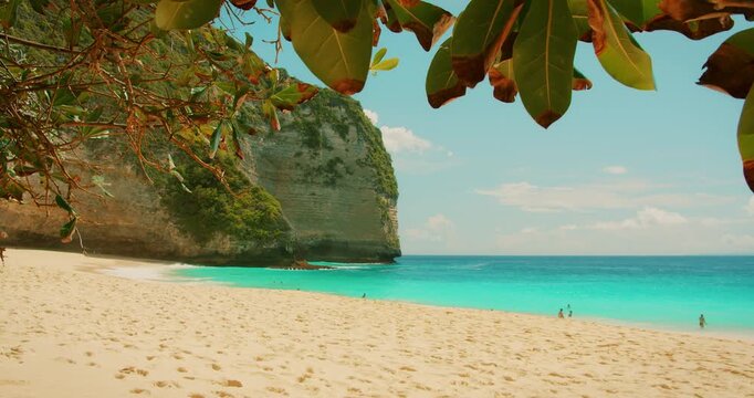 Turquoise ocean waves reaching the white sandy shore of Nusa Penida Bali