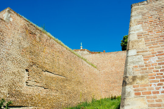 View of the massive brick walls of Kalemegdan Fortress with the Pobednik monument standing against a clear blue sky in Beograd, Grad Beograd, Serbia.