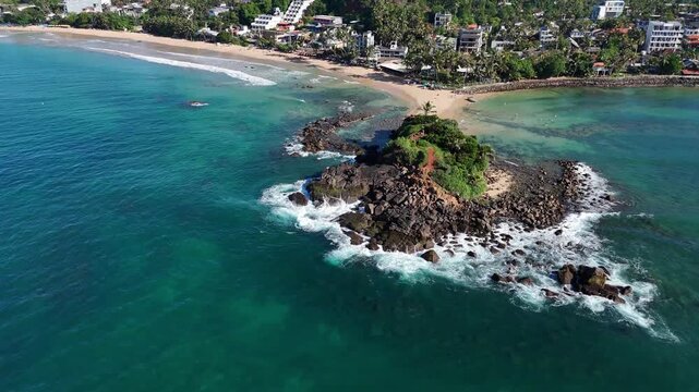 Wide aerial panorama of Mirissa Beach with the rocky island of Parrot Rock in the ocean. Mirissa, Sri Lanka