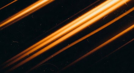 Obraz premium Abstract golden light streaks on a dark background with vintage film grain texture