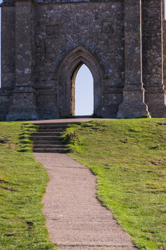Ancient St Michaels Tower on Glastonbury Tor with Bright Sun Flare and Clear Sky
