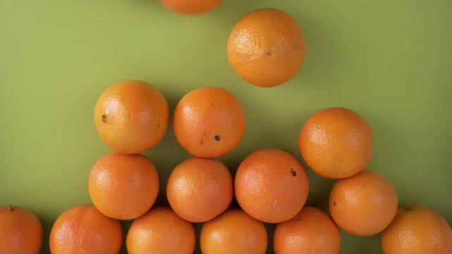 Group of oranges falling on a green background