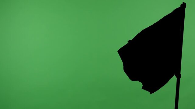 Black flag on a pole against a green background with alpha channel. Concept of symbol, protest, warning, anonymity, and chroma key element for video editing and design.