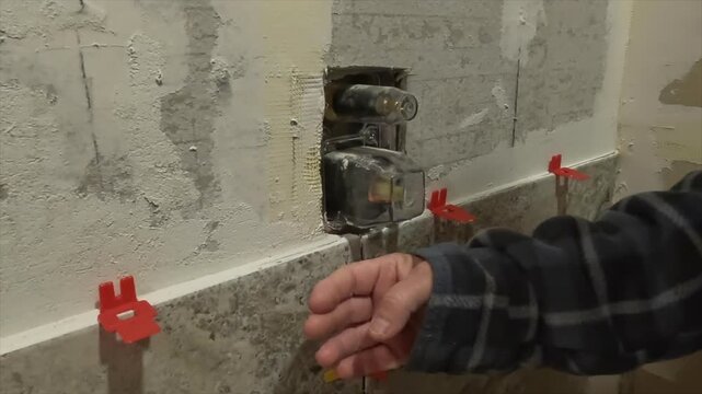 Women pointing out tile and shower diverter